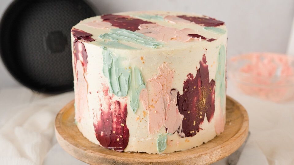 Buttercreme-Torte verziert mit bunten Farbklecksen