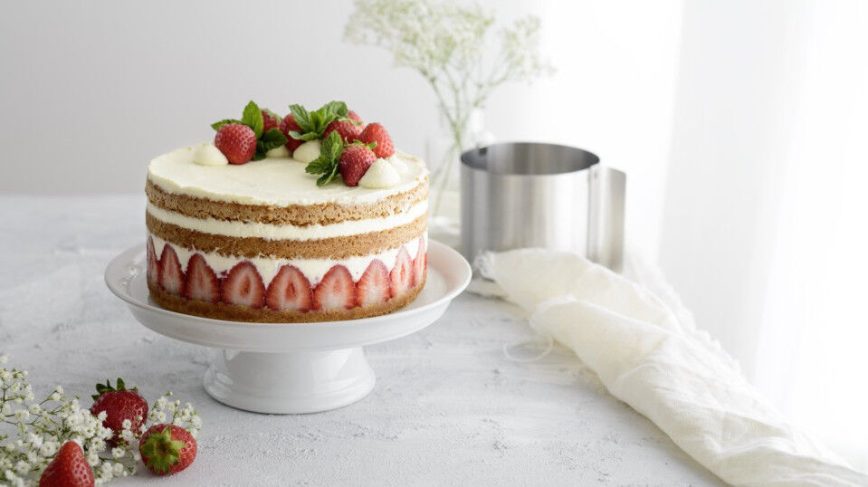 Torte dekoriert mit Erdbeeren und Sahne-Creme