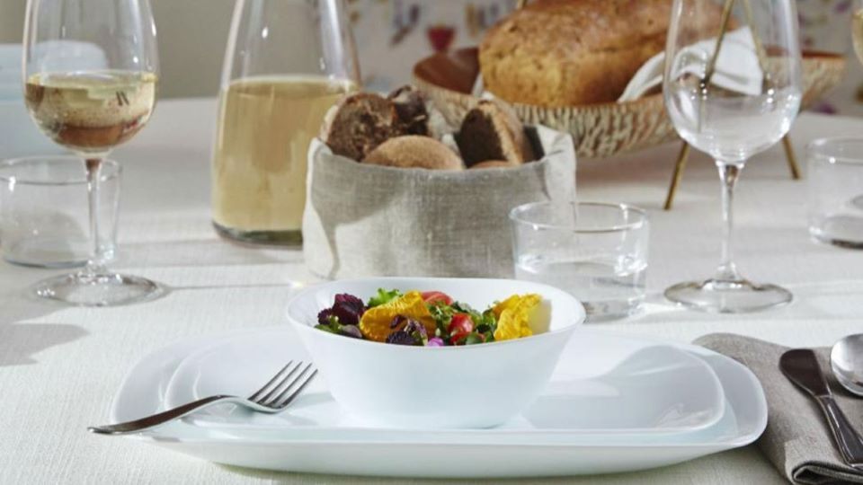Gedeckter Tisch mit kleiner Salatschüssel, Wein & Brot
