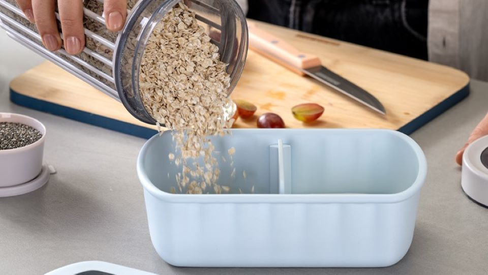 Haferflocken werden in hellblaue Aufbewahrungsbox gefüllt