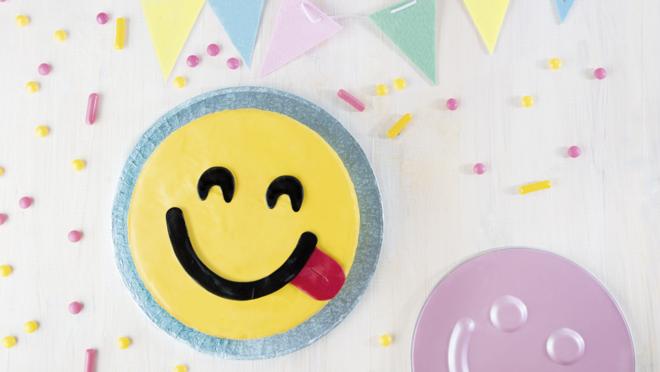 Runder Smily-Kuchen, daneben die entsprechende Springform Runder Smily-Kuchen, daneben die entsprechende Springform