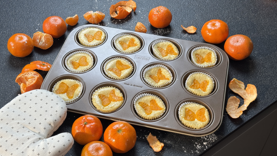 Käsekuchen-Muffins mit Mandarinen in einem Muffinblech