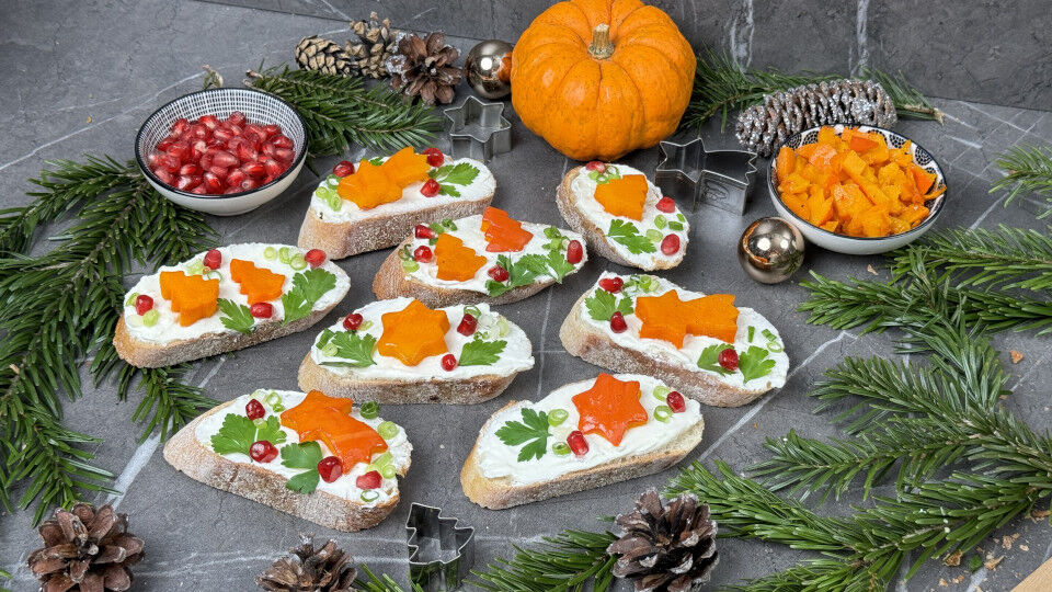Weihnachtliche Bruschetta mit gebackenem Kürbis, umrandet von Tannenzweigen