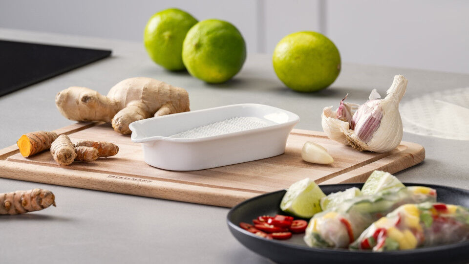 Schneidebrett mit Knoblauch, Ingwer und Limetten