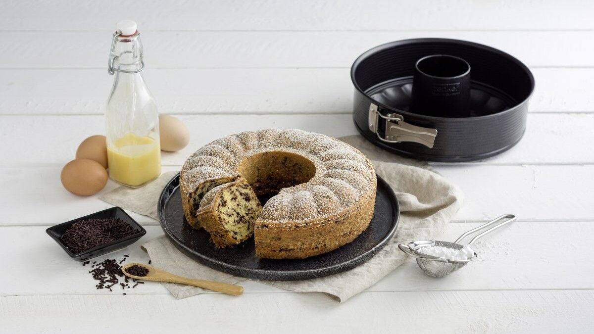 Rührkuchen aus Springform mit Eiern und Eierlikör im Hintergrund