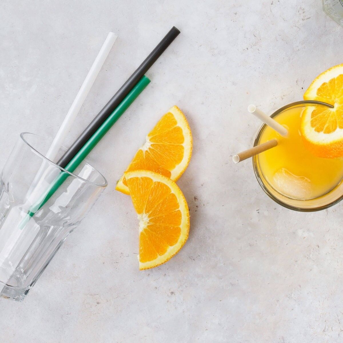 Wiederverwendbare Strohhalme aus Glas, Plastik und Papier in zwei Gläsern Wiederverwendbare Strohhalme aus Glas, Plastik und Papier in zwei Gläsern