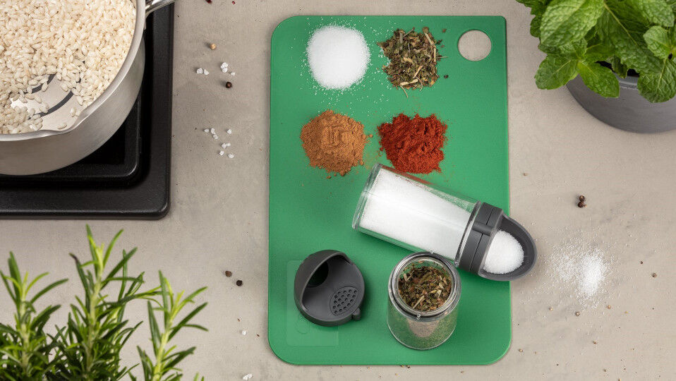Schneidebrett mit verschiedenen Gewürzen und Streuer