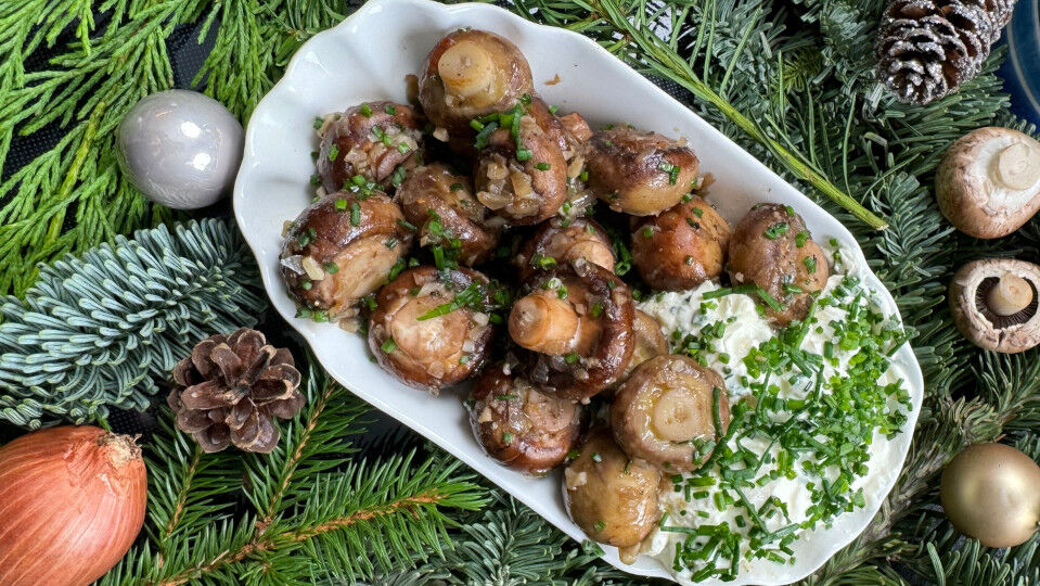 Champignons mit Kräuterdip in einer Schale, umrahmt von Tannenzweigen