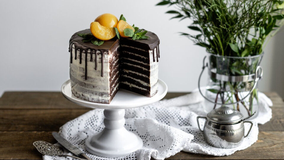 Torte verziert mit Schoko-Drip und Pfirsichen