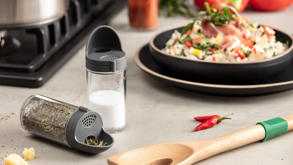 Gewürzstreuer mit leckerem Gericht im Hintergrund