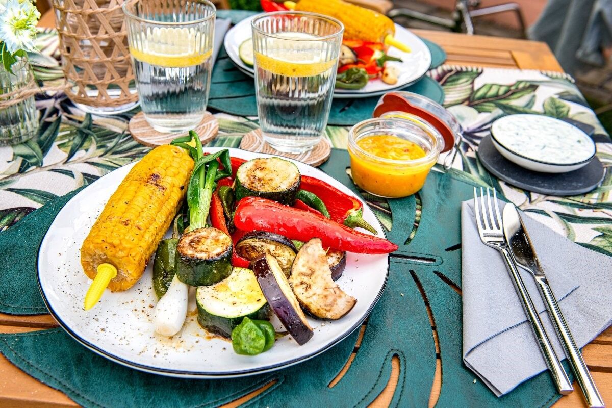 Zucchini grillen: Gegrillte Zucchini und anderes Grillgemüse auf einem gedeckten Gartentisch Zucchini grillen: Gegrillte Zucchini und anderes Grillgemüse auf einem gedeckten Gartentisch